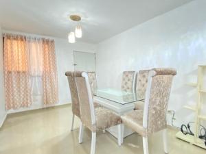comedor con mesa de cristal y 2 sillas en Elegant 3 bed apartment in Santiago DR, en Santiago de los Caballeros