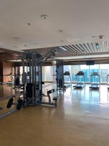 a gym with rows of tread machines in a room at 1 Bedroom Executive Suite apartment at The H Tower Kuningan Jakarta by Lorenso in Jakarta