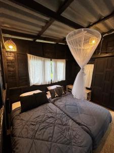 Schlafzimmer mit einem Bett mit Moskitonetz in der Unterkunft The Legend Homestay. in Mae Ai Chiang Mai