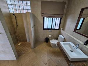 y baño con lavabo, aseo y ducha. en Baan Jai Dee Beach Front Hotel en Wok Tum
