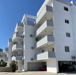 un edificio de apartamentos con balcones y aparcamiento en Cyprus Penelope en Lárnaca