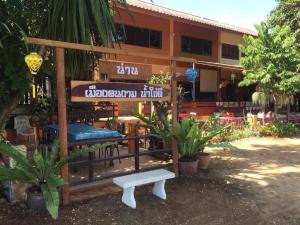 a building with a bed and a bench in front of it at Good View Nan Restaurant & hotel in Nan