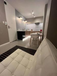 a white room with a table and a white couch at Perfect Lock Up & Go Apartment in Cape Town