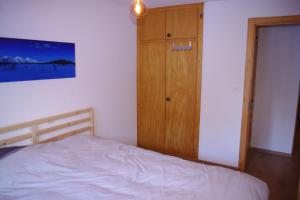 1 dormitorio con 1 cama y armario de madera en à 2 pas du télécabine en Zinal