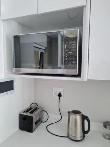 a microwave sitting on a kitchen counter with a toaster at 116 The Esplanade in Hermanus