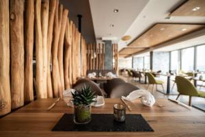 a dining room with a table and chairs and a wall of logs at Kulmberghaus Resort in Saalfeld