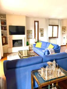 uma sala de estar com um sofá azul e uma lareira em Casa Ila em Florença