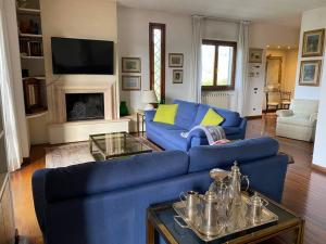 a living room with a blue couch and a fireplace at Casa Ila in Florence
