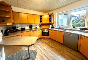una cocina con armarios de madera y una mesa. en Boardinghouse Miltenberg, en Miltenberg