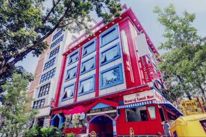 a red building with blue windows on a street at Collection O Sabharwal Inn in Bangalore