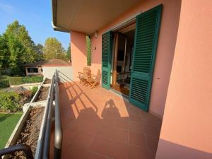 einen Balkon mit grünen Rollläden an einem Haus in der Unterkunft Casa Ila in Florenz