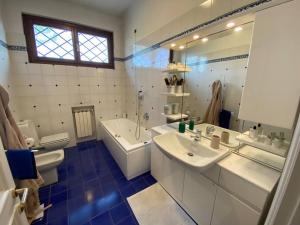 uma casa de banho com 2 lavatórios, uma banheira e um WC. em Casa Ila em Florença