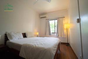 a bedroom with a white bed and a window at Les Jardins Du Bassac in Phnom Penh +31 photos