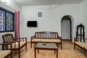 - un salon avec des chaises, un canapé et une table dans l'établissement Super OYO Pravin Holiday Homes, à Calangute