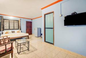a bedroom with a bed and a flat screen tv at Super OYO Pravin Holiday Homes in Calangute