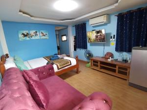 a living room with a couch and a bed at Tonkaew Khaokao Resort in Campson