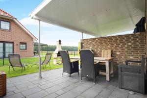 a patio with a table and chairs and a brick wall at Speicherhäuschen Maren in Geeste