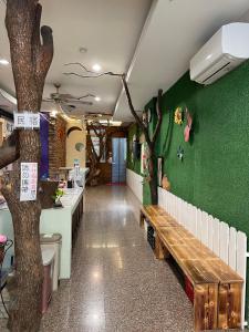 a restaurant with a bench and a tree on the wall at Mei Jen House B&B 民宿 in Yuchi