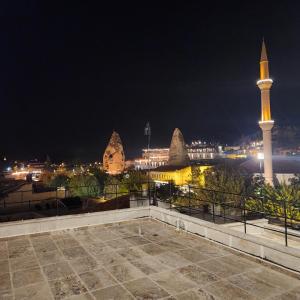 uma vista da cidade à noite com uma mesquita em Noah's Ark Cave Hotel em Goreme
