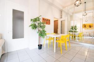 a dining room with a table and yellow chairs at Chic Kastella Apt by Mikrolimano in Piraeus