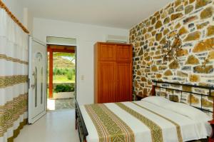 a bedroom with a bed and a stone wall at Albatros Studios & Apartments in Plakias