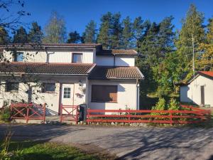 een huis met een rood hek ervoor bij very comfortable room in a unique villa in Gävle