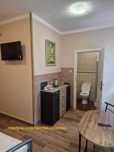 Habitación con baño con aseo y mesa. en Centrum Noclegowe II, en Bydgoszcz