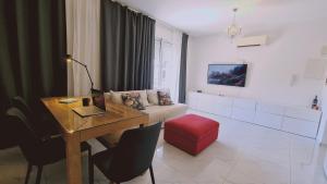 STAY W Apartment في ليماسول: غرفة معيشة مع طاولة وأريكة
