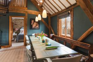 a dining room with a long table and chairs at Meadow End Barn in Dorstone