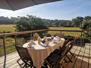 a table with a white table cloth on a deck at Les Prés Grand Lodge in Montigné-le-Brillant