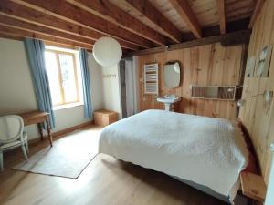 1 dormitorio con cama, lavabo y espejo en Les Prés Grand Lodge en Montigné-le-Brillant