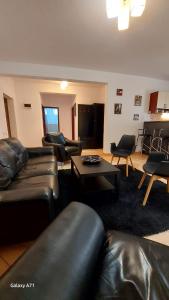 a living room with leather couches and a table at Apartament Roland in Poiana Brasov