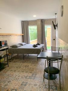 a bedroom with two beds and a table and a desk at Apartamentos La Ruta in Calpe