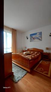 a bedroom with a large wooden bed in a room at Apartament Roland in Poiana Brasov