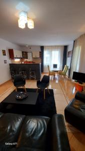 a living room with a couch and chairs and a kitchen at Apartament Roland in Poiana Brasov