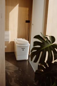 a plant sitting next to a trash can in a room at WonderInn Riverside in Årnes