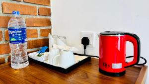 a red kettle and a bottle of water on a counter at Salubrious Resort in Anuradhapura