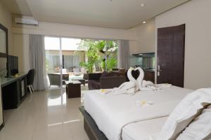 a bedroom with a bed with two swans on it at Sunset Mansion Seminyak in Seminyak