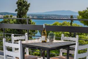 Una botella de vino sentada en una mesa con sillas en Genesis Hotel, en Loutraki