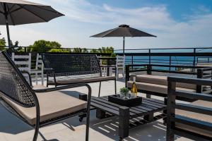 a patio with chairs and a table with an umbrella at Genesis Hotel in Loutraki