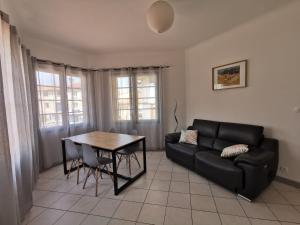 a living room with a black couch and a table at Le Glacis in Collioure