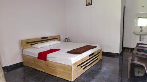 a bedroom with a wooden bed with a red ribbon on it at Backwaters Retreat in Ankola