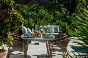 una mesa y sillas en un patio con sombrilla en Villa Seraphina, en Zaton