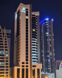 um grupo de edifícios altos em uma cidade à noite em S Hotel Bahrain em Manama