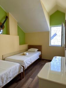a small room with two beds and a window at Old stone house St Lawrence in the heart of Sibenik's old town in Šibenik