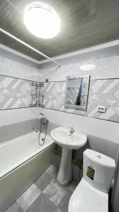 y baño con lavabo, aseo y bañera. en Family apartment 4 en Shymkent