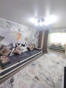 Habitación con sofá y almohadas. en Family apartment 4 en Shymkent