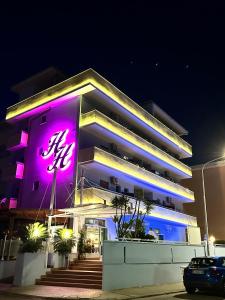 a building with a purple sign on it at night at Hotel Holiday in Martinsicuro