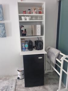 een kleine keuken met een zwarte koelkast in een kamer bij 12onParkesLane in Knysna