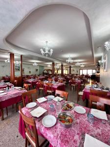 una sala da pranzo con tavoli e sedie con tovaglie rosa di Hotel Holiday a Martinsicuro